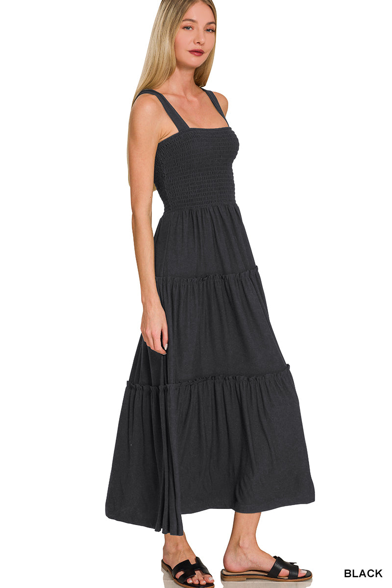 Woman wearing a black tiered dress on a white background