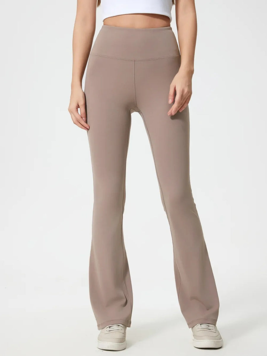 Beige flared pants worn by a person on a white background