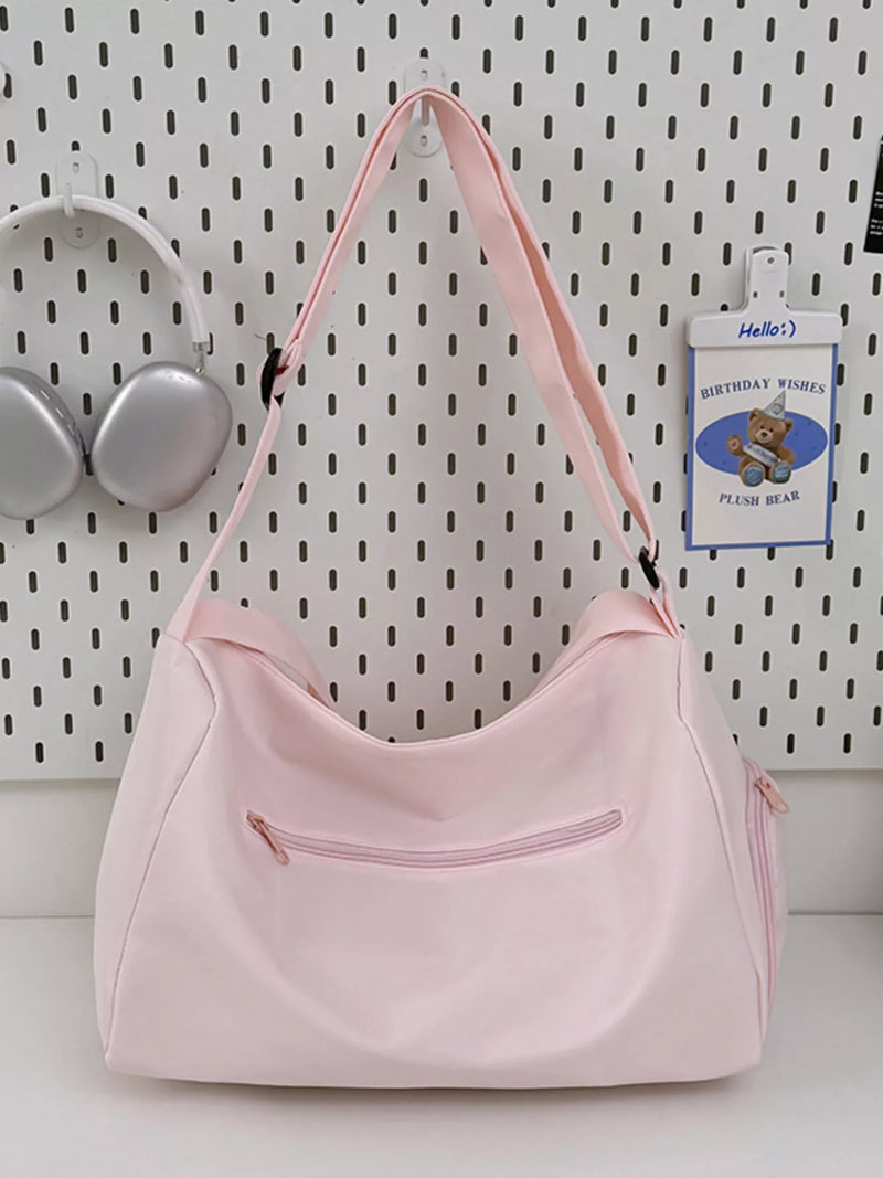 Pink handbag on a white surface with a pegboard background