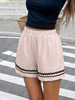 Person wearing beige shorts with black trim on a crosswalk