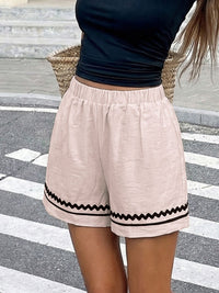 Person wearing beige shorts with black trim on a crosswalk
