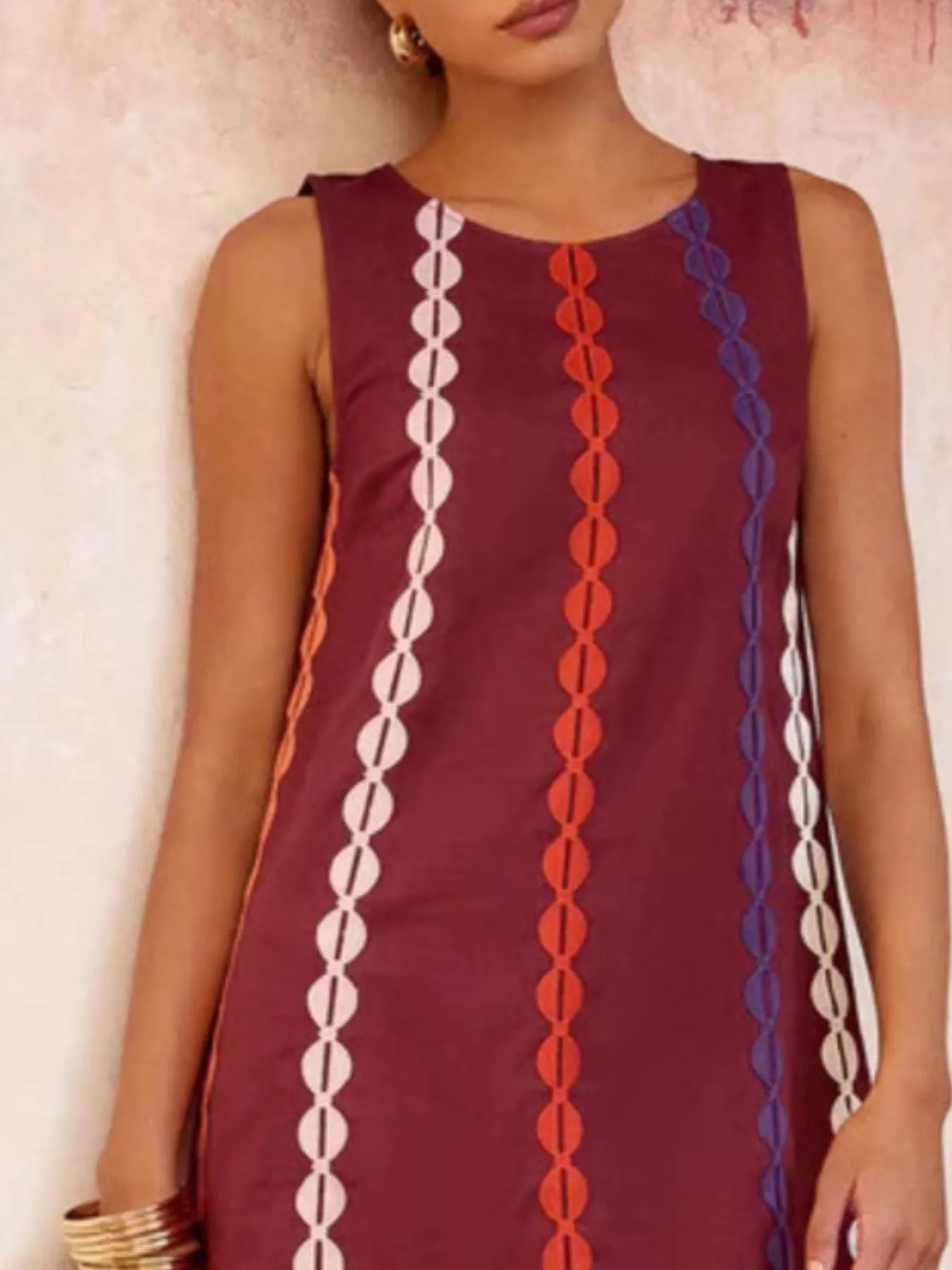 Maroon sleeveless dress with colorful geometric patterns on a plain background