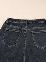 Close-up of a pair of dark blue jeans with a beige background