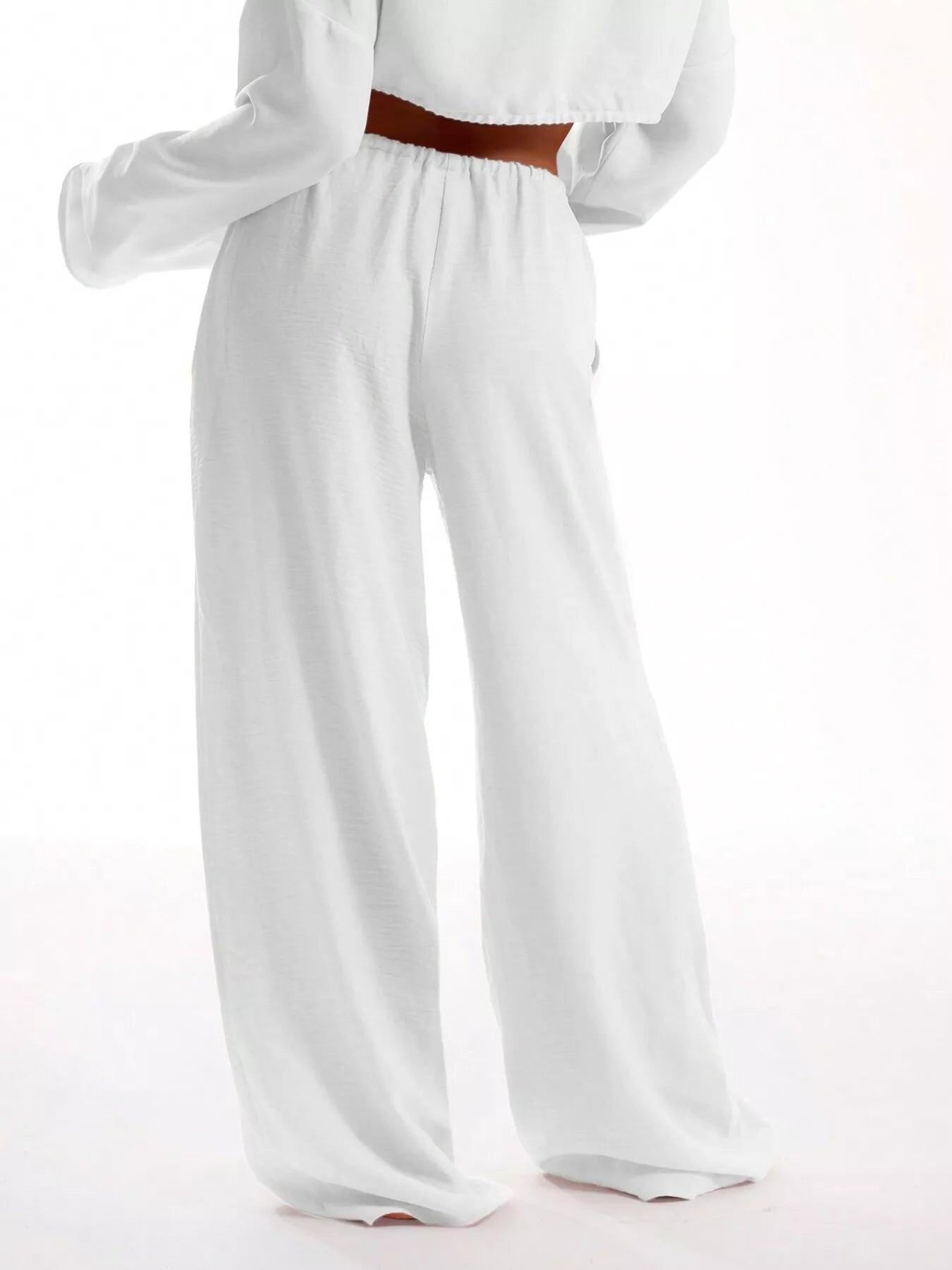 White wide-leg pants worn by a person on a white background