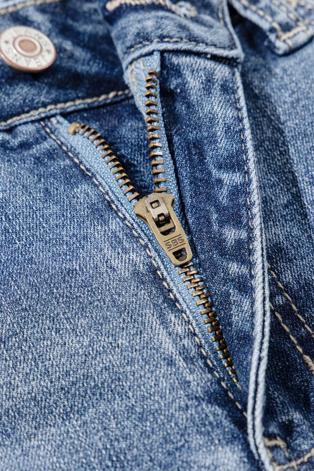 Close-up of a blue denim jacket with a zipper