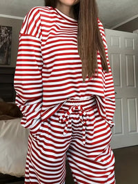 Person wearing red and white striped pajamas in a room.