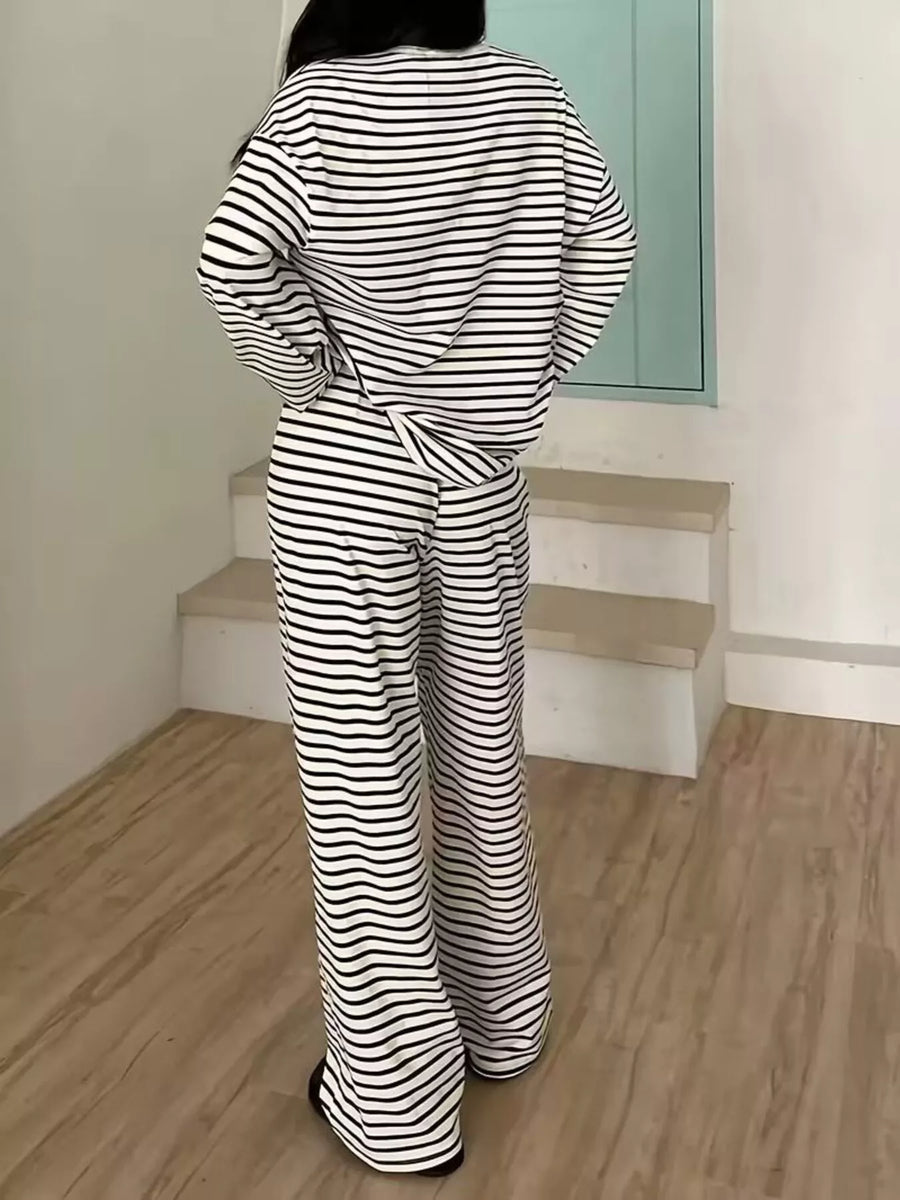 Person wearing a black and white striped outfit standing on a staircase.