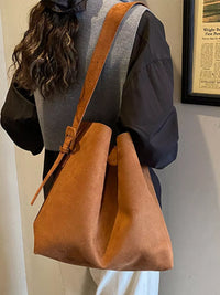 Person holding a brown leather bag indoors