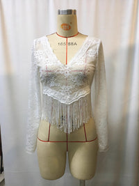 Mannequin wearing a white lace top with fringe details against a plain background