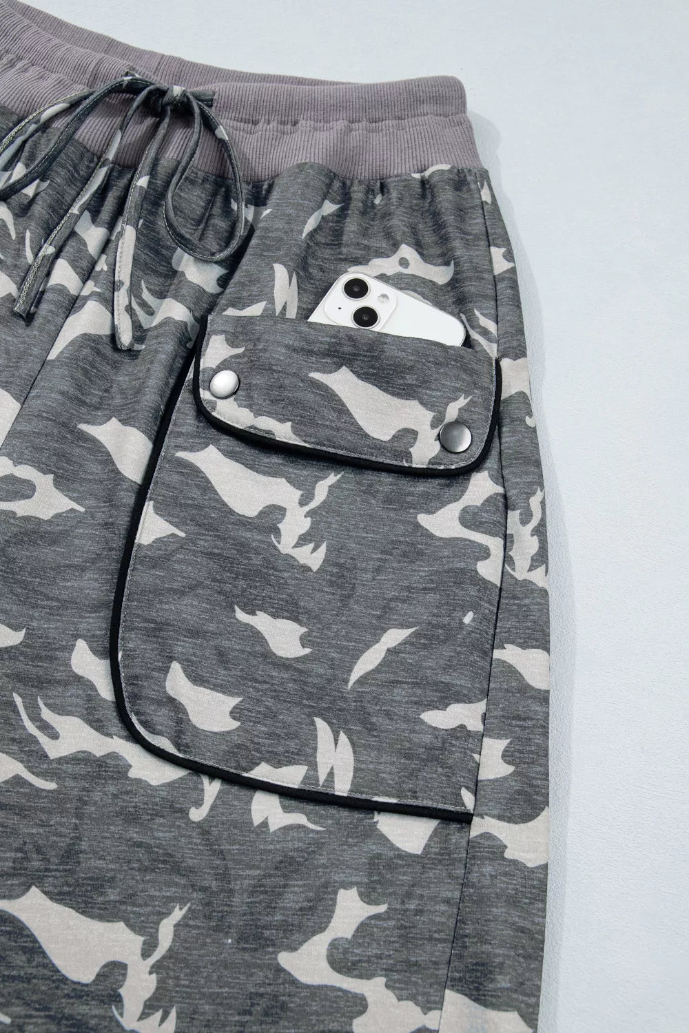Gray camouflage pants with a pocket on a light gray background