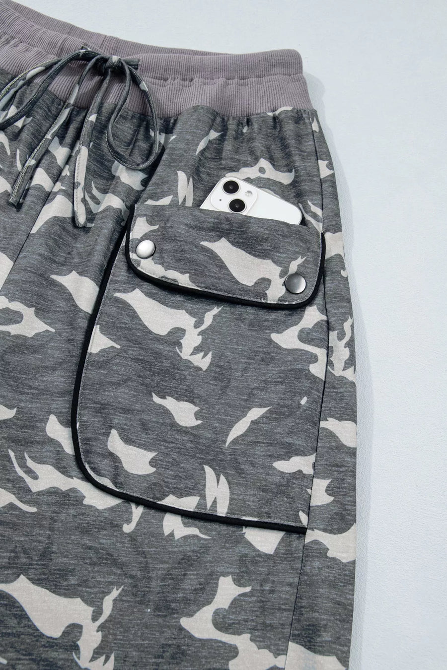 Gray camouflage pants with a pocket on a light gray background
