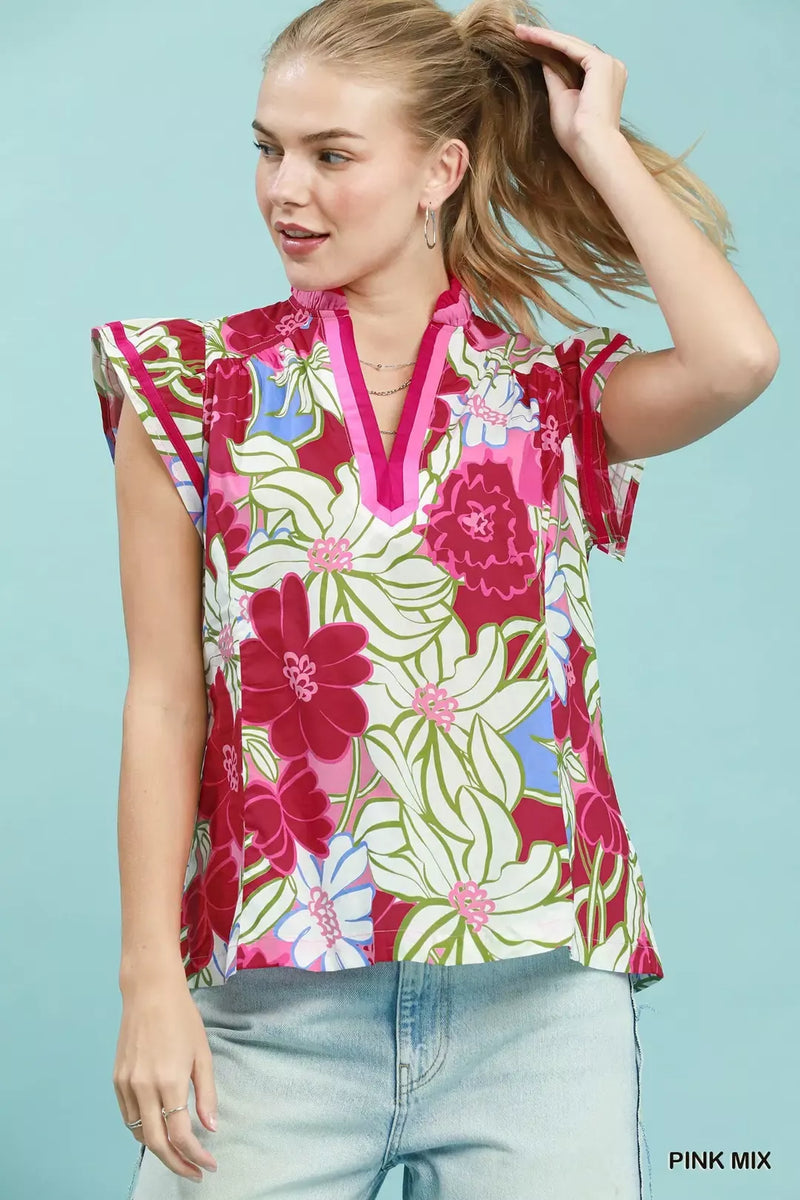 Woman wearing a colorful floral blouse against a light blue background