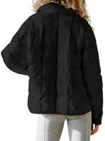 Black puffer jacket worn by a person on a white background