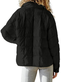 Black puffer jacket worn by a person on a white background