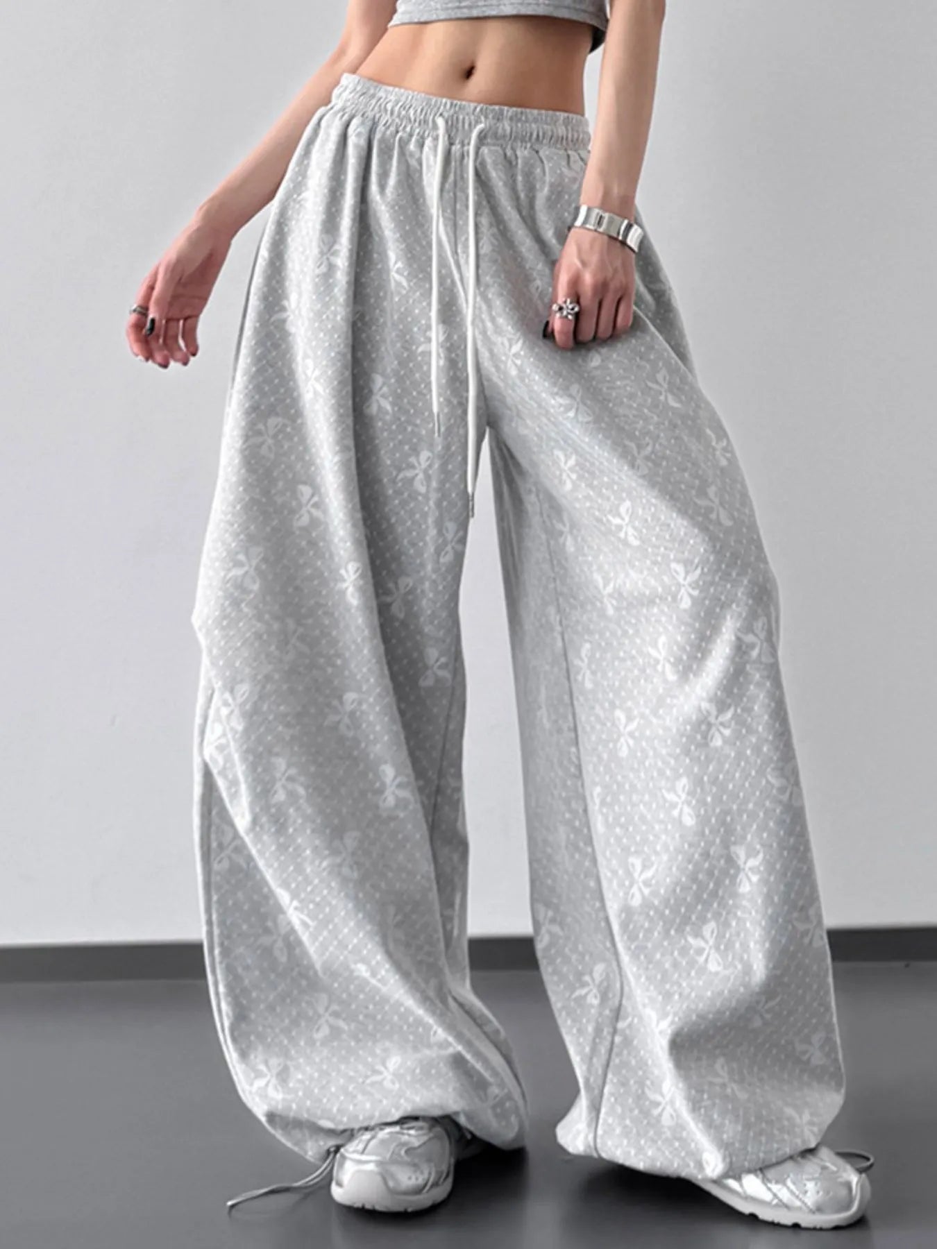 Person wearing light gray wide-leg pants on a plain background