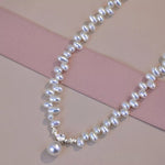 Pearl necklace with a diamond clasp on a pink and beige background
