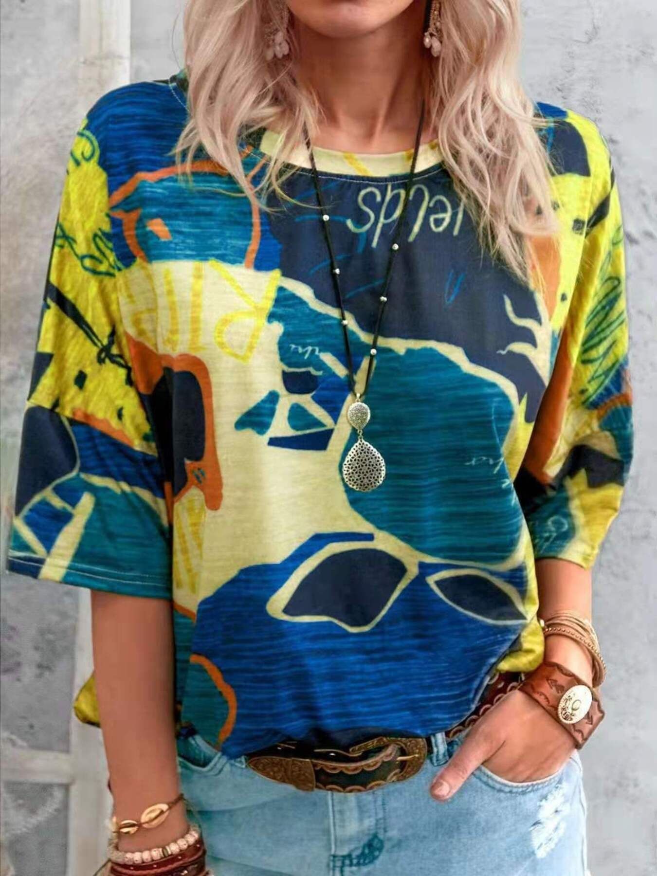 Person wearing a colorful graphic t-shirt with abstract designs on a plain background