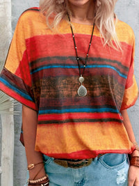 Person wearing a colorful striped shirt with a pendant necklace against a neutral background