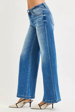 Blue jeans worn by a person on a light gray background