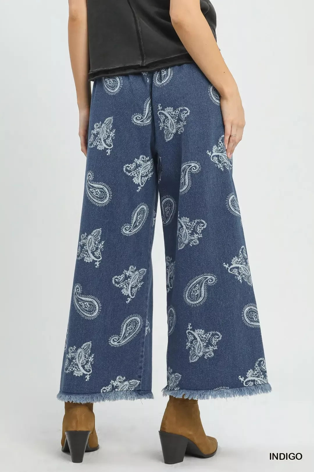 Blue paisley-patterned jeans worn by a person on a white background
