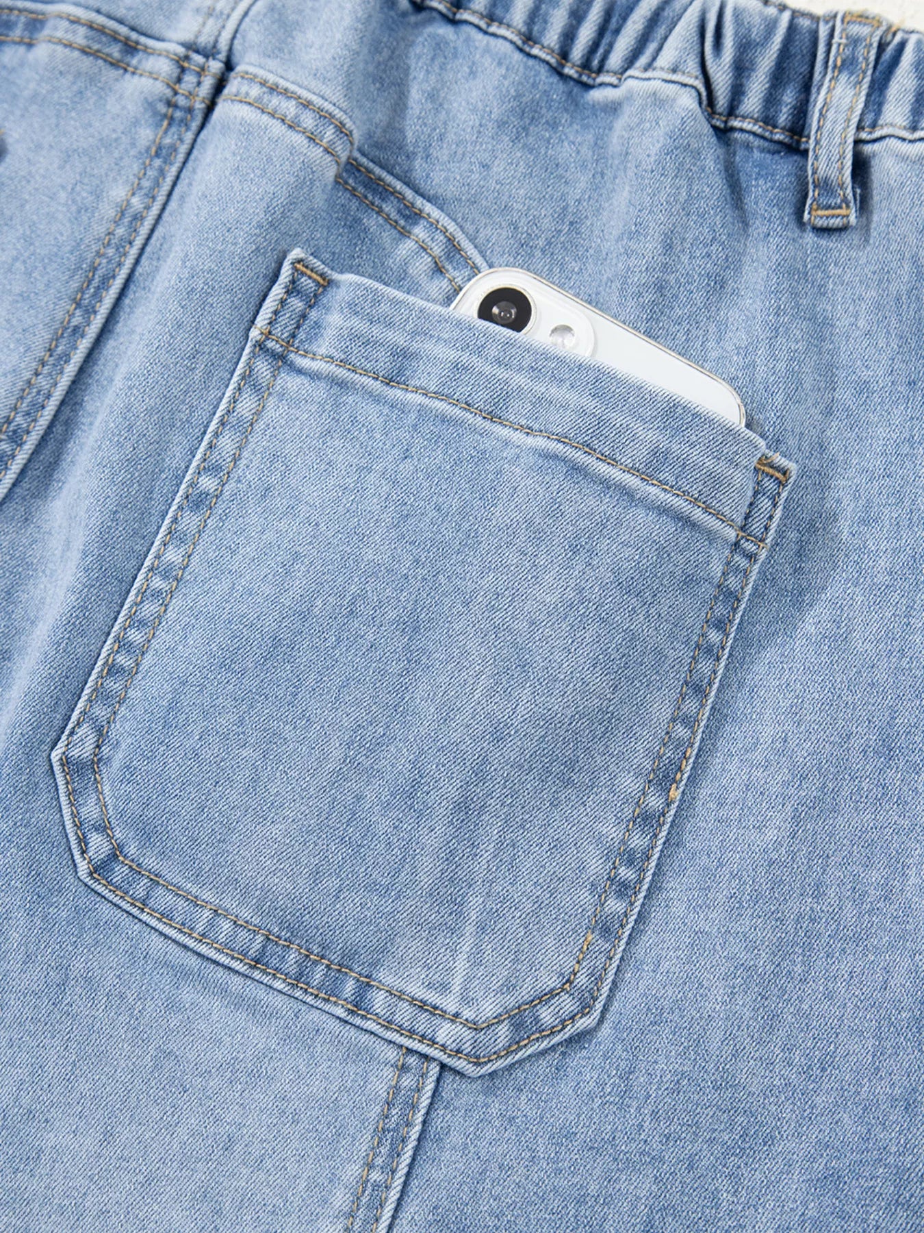 Close-up of a blue denim pocket with a smartphone inside