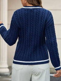 Person wearing a blue cable knit sweater with white trim