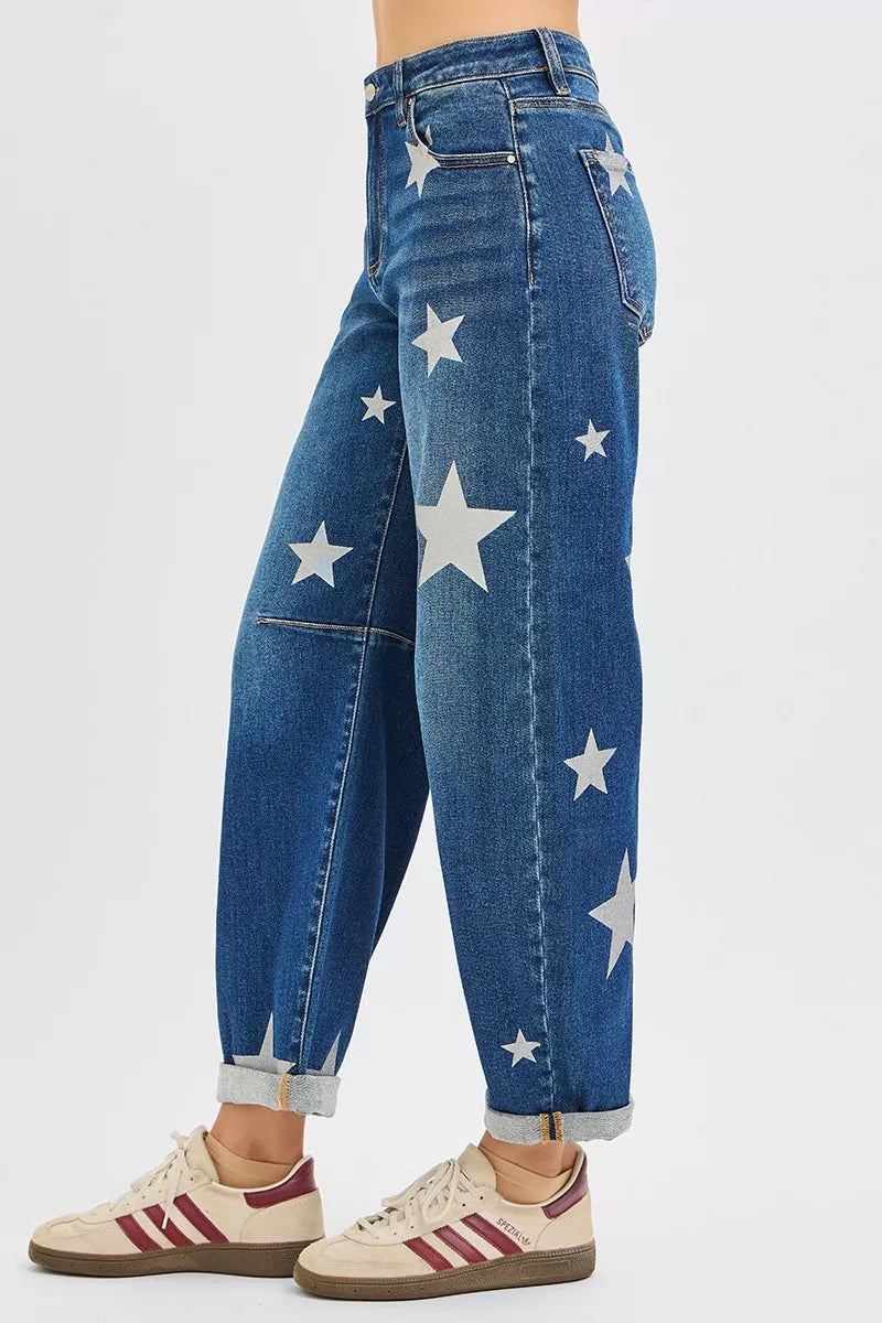 Blue jeans with white star patterns worn by a person on a light gray background