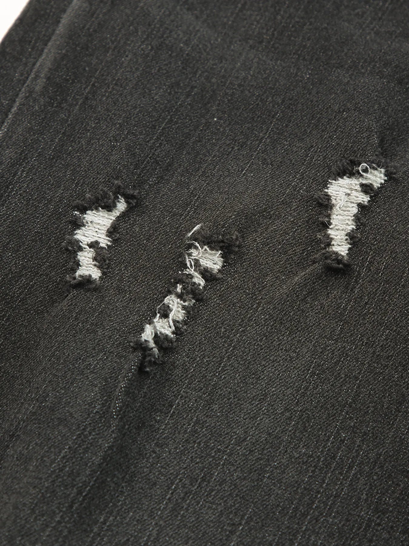 Close-up of a textured black surface with white embroidered patterns.