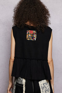 Person wearing a black sleeveless top with a colorful pocket on a gray background
