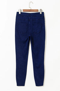 Blue jeans on a hanger against a white background