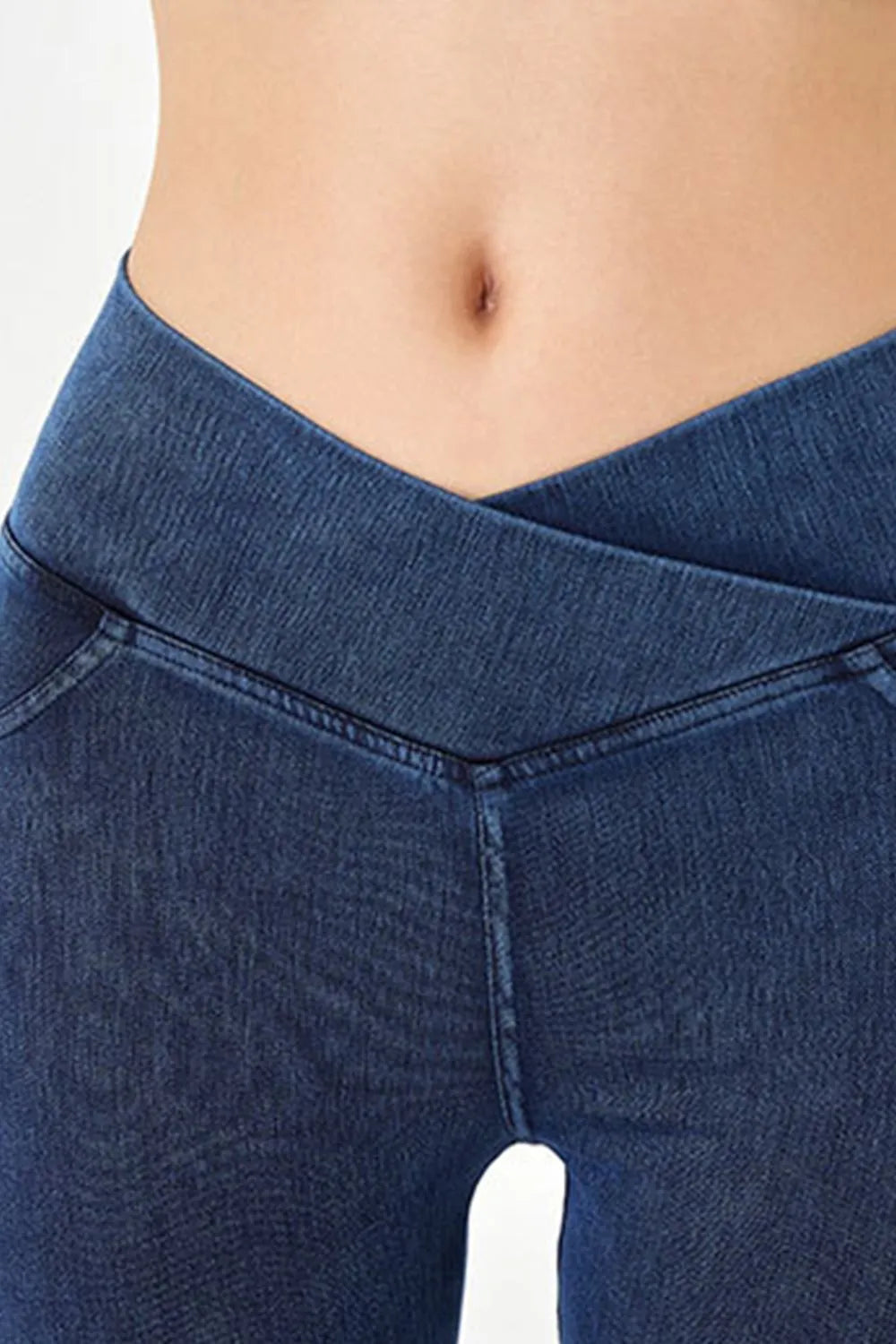 Close-up of blue jeans worn by a person on a white background