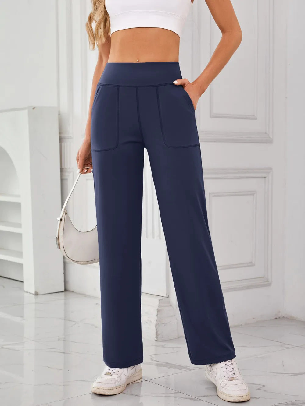 Person wearing navy blue pants with a white background