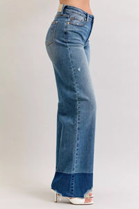 Blue jeans worn by a person on a plain background