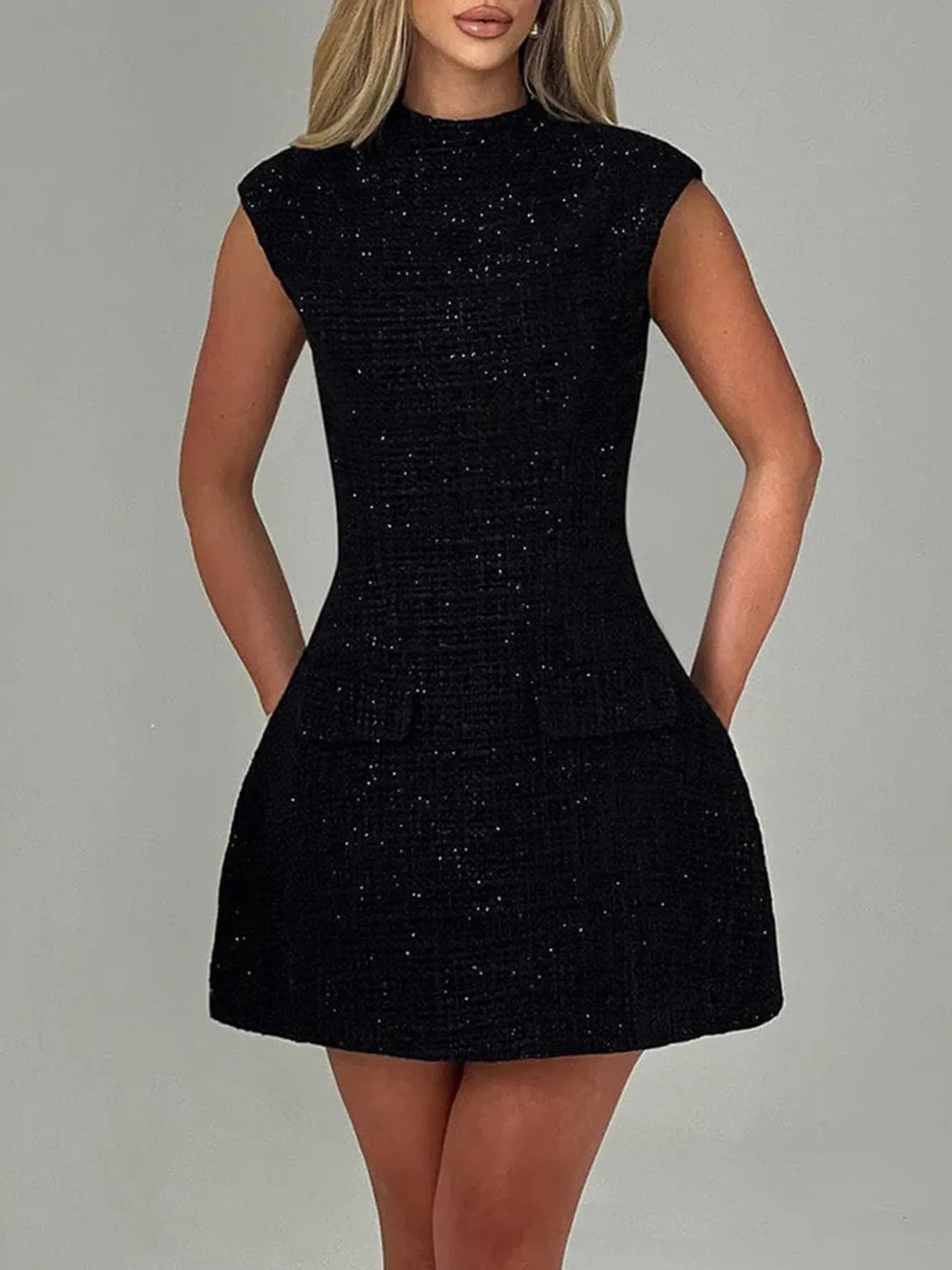 Black dress worn by a model on a gray background