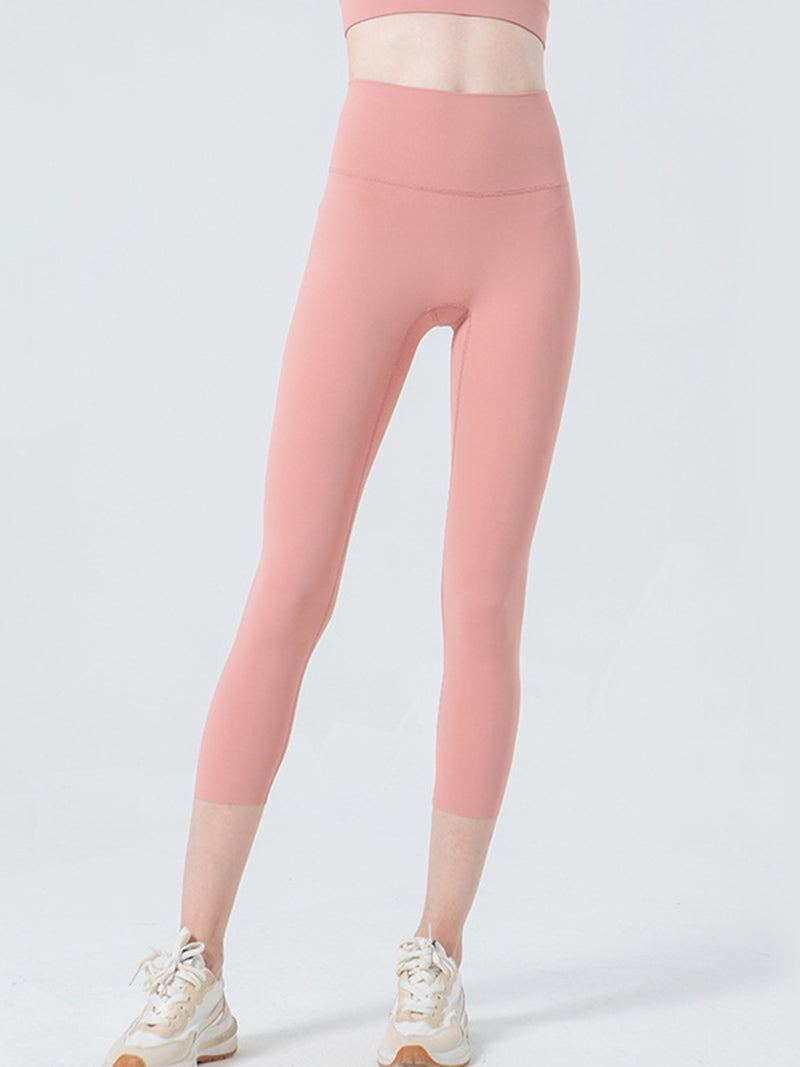 Pink leggings worn by a person on a light gray background