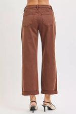 Brown pants worn by a person on a white background