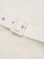 Close-up of a white belt with a buckle on a light gray background