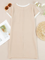 Beige ribbed dress on a neutral background with sunglasses and flowers.