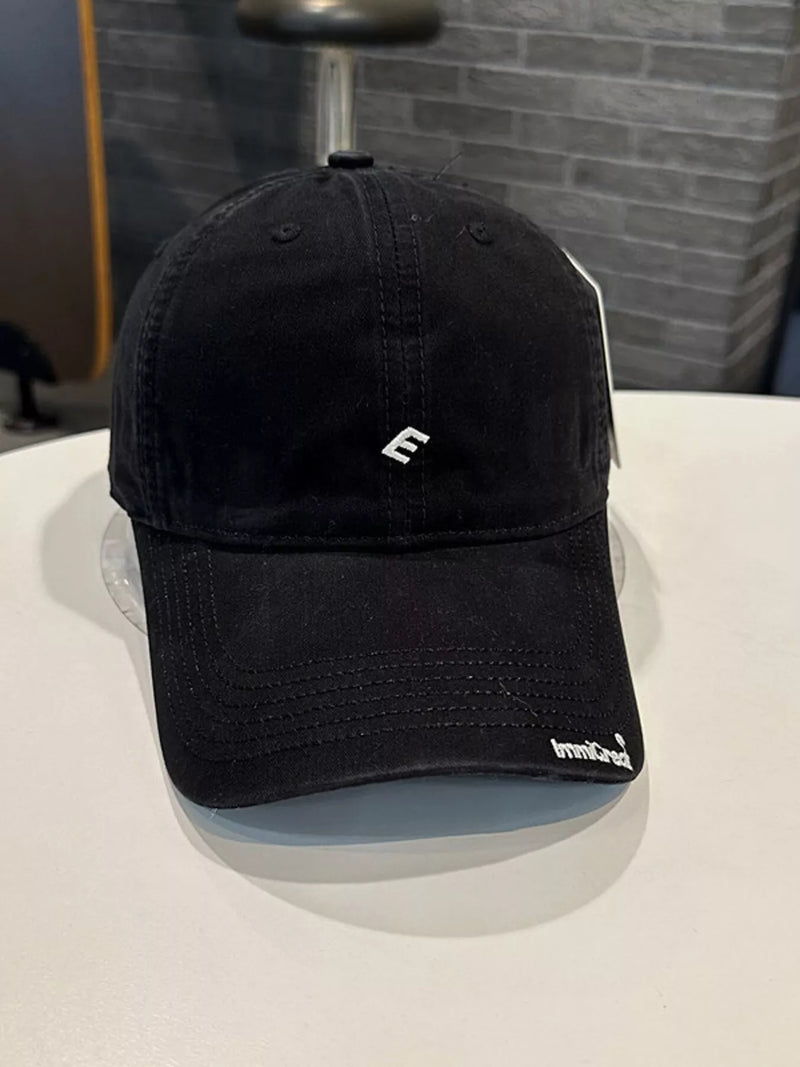 Black cap with a logo on a white surface
