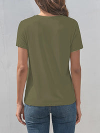 Person wearing a green t-shirt and blue jeans against a gray background