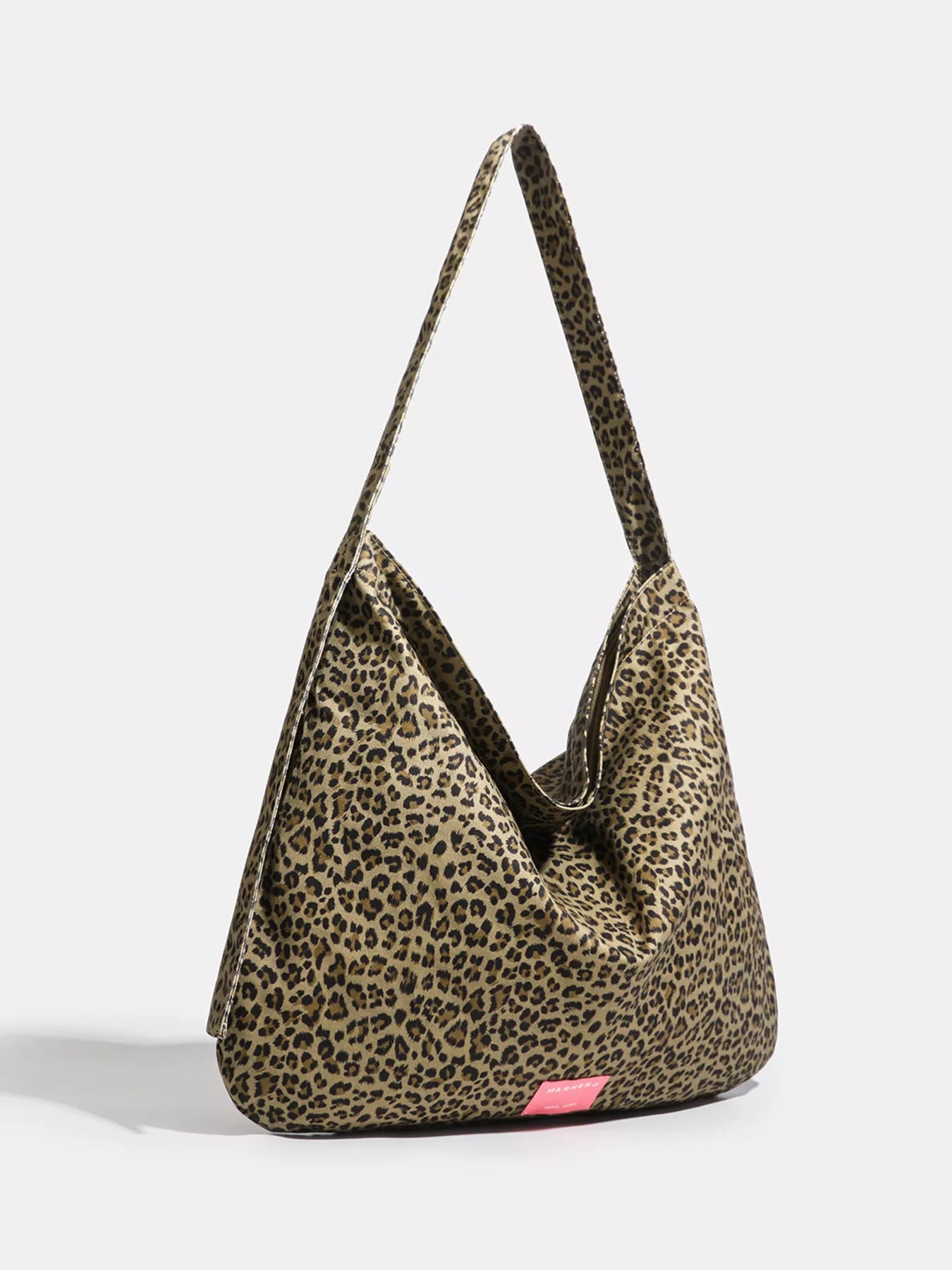Leopard print handbag with a pink tag on a white background