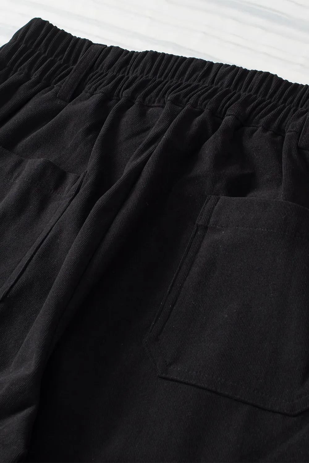 Close-up of black shorts with an elastic waistband on a white background