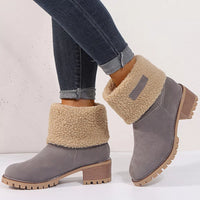 Gray ankle boots with beige sherpa lining worn with rolled-up jeans on a light background