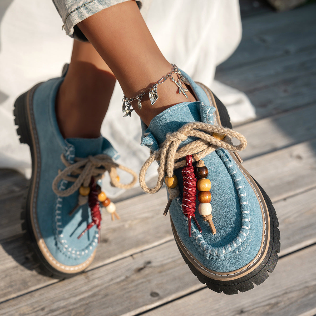 Blue suede shoes with decorative elements on a wooden floor
