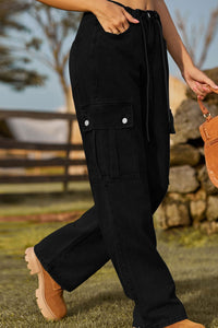 Person wearing black cargo pants with a blurred natural background