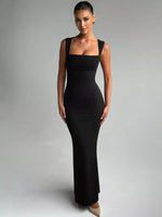 Woman wearing a black evening gown against a gray background