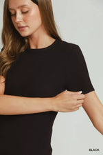 Woman wearing a black top against a neutral background