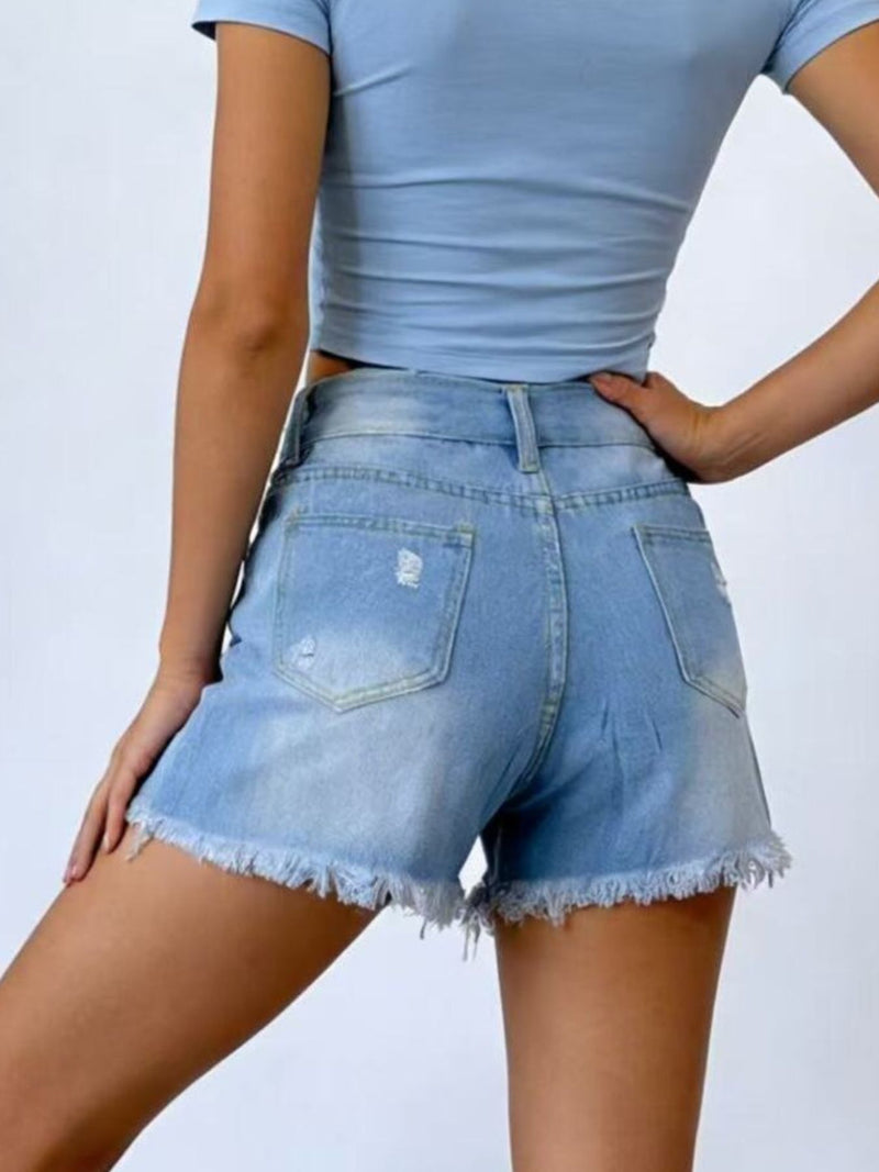 Person wearing light blue denim shorts and a matching top on a plain background
