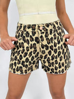 Leopard print shorts worn by a person on a plain background