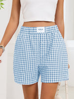 Blue and white checkered shorts worn by a person on a light background